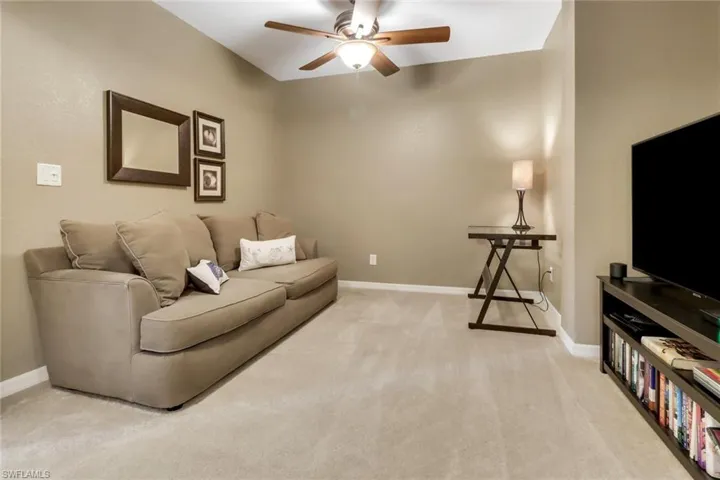 Living room featuring ceiling fan and carpet floors