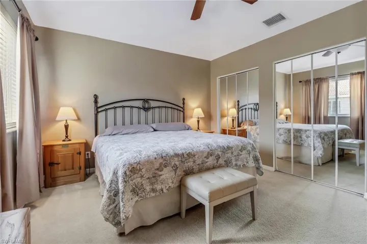 Bedroom featuring carpet flooring, two closets, and ceiling fan