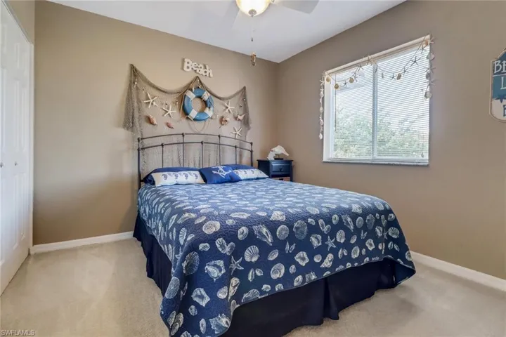 Carpeted bedroom with a closet and ceiling fan