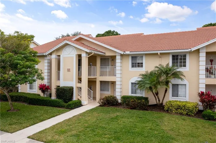 View of front facade with a balcony and a front lawn