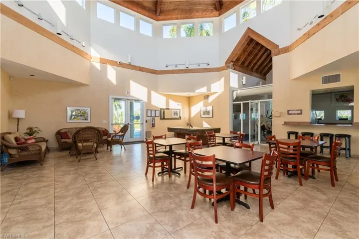 Tiled dining space featuring high vaulted ceiling, wood ceiling, and rail lighting
