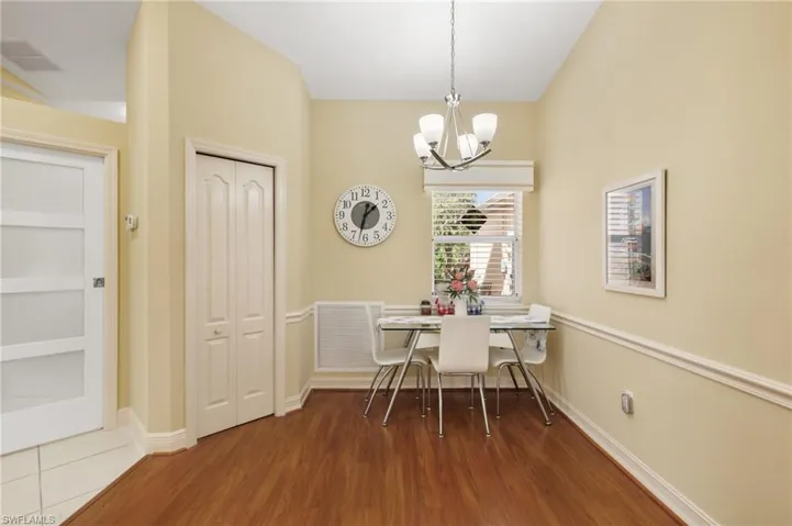 Dining room with dark wood-style flooring, a chandelier, and breakfast area