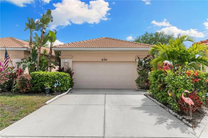 View of front of house with a tiled roof, concrete driveway, stucco siding, and a garage