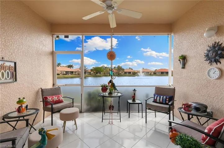 Sunroom featuring a textured wall, a residential view, and a water view