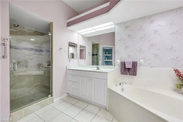 Primary bathroom with double vanity, garden tub, shower and water closet.