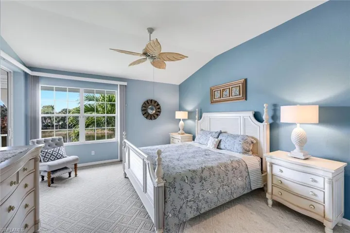 Primary bedroom with lots of natural light, carpeted flooring and beautiful views of the fountains and lake with private entrance to the patio.