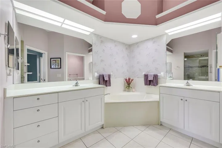 Primary bathroom with double vanity, garden tub, shower and water closet.
