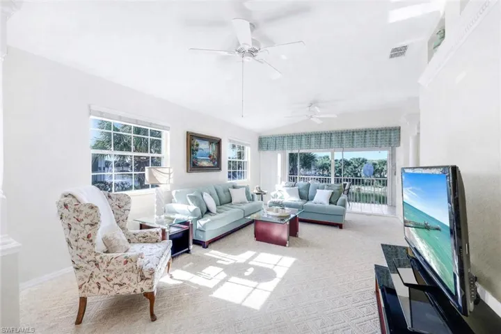 (Virtual wall color change) Spacious living room with lots of natural light, carpeted flooring and beautiful view from the 2nd story overlooking the lake.