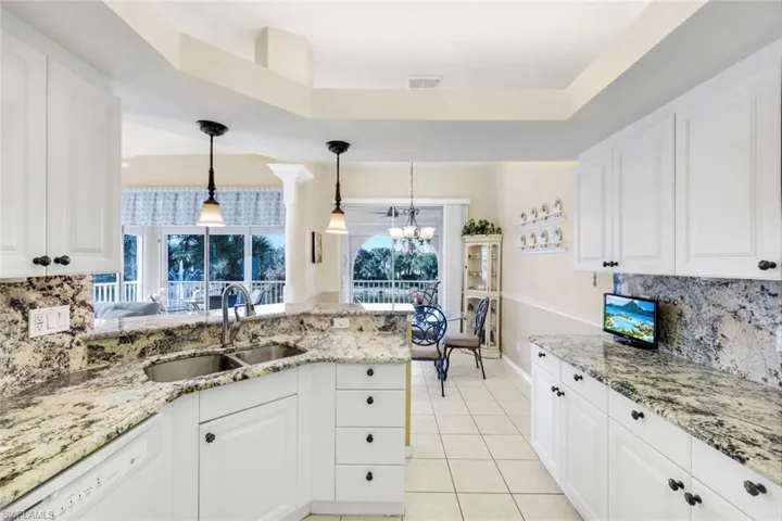 (Virtual wall color change) Large kitchen with granite countertops, bar seating, plenty of cabinetry for storage and large pantry.