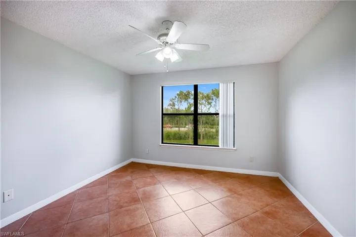 Spare room featuring a textured ceiling, tile patterned floors, and ceiling fan