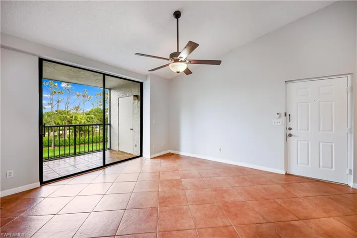 Tiled empty room featuring a textured ceiling, ceiling fan, and high vaulted ceiling