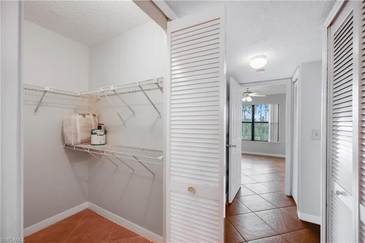 Spacious closet featuring tile patterned floors and ceiling fan