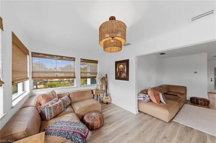 Living area featuring light wood-type flooring and hanging lights