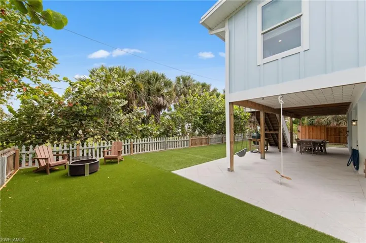 Fenced backyard with outdoor dining space and a patio.