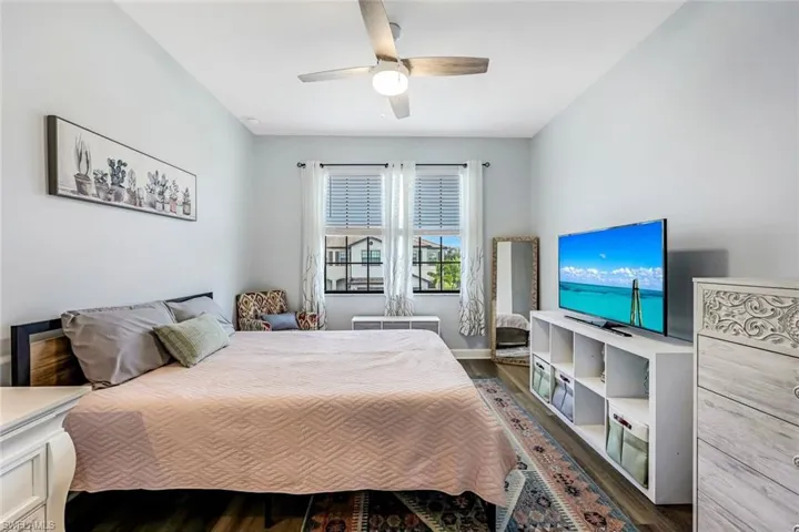 Bedroom with ceiling fan and dark hardwood / wood-style flooring
