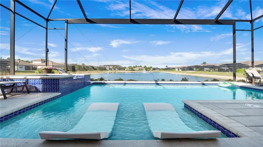 View of pool with glass enclosure, a sunroom, a patio, a water view, and a residential view