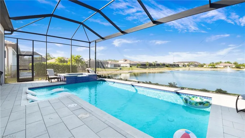 View of swimming pool with a water view, a sunroom, a patio, a pool with connected hot tub, and a lanai