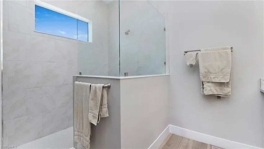 Full bathroom featuring walk in shower and wood finished floors