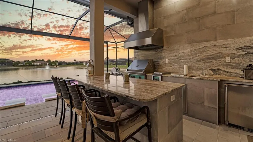 View of patio / terrace with a lanai, a water view, a sunroom, and a grill