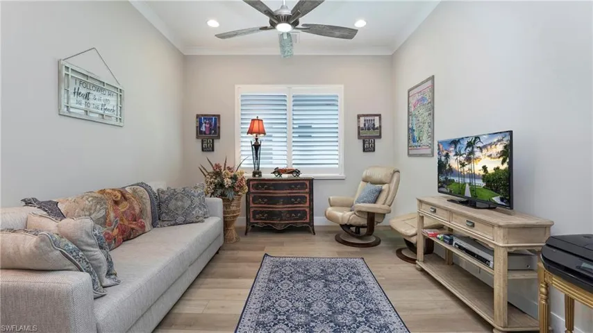 Living room with crown molding, light wood-style floors, ceiling fan, and recessed lighting