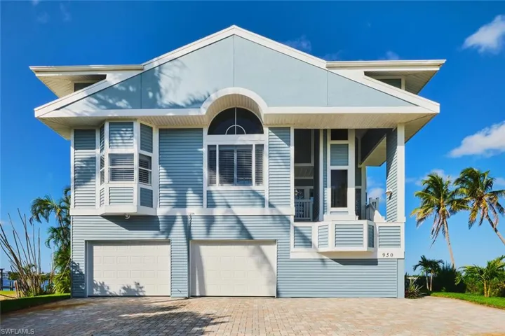View of front of property featuring decorative driveway, a garage, and a balcony