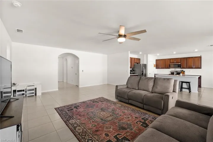 Living room featuring light tile patterned floors and ceiling fan