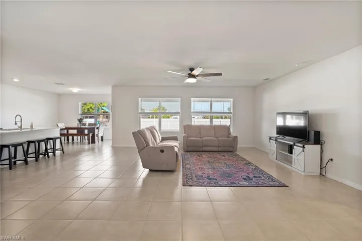 Tiled living room with ceiling fan and sink