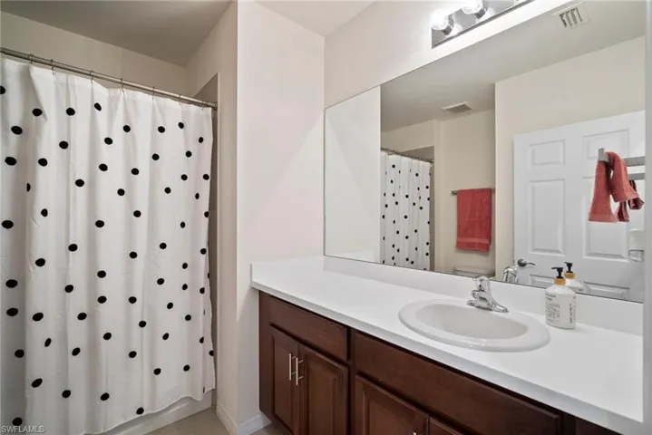Bathroom with a shower with curtain, vanity, and toilet