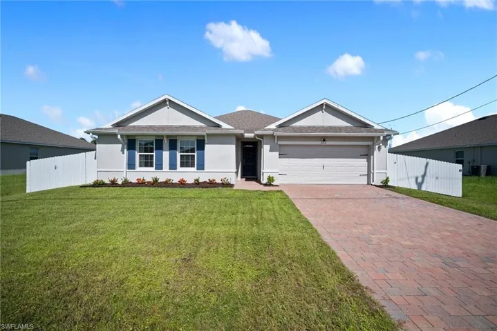 Ranch-style home with cooling unit, a garage, and a front lawn