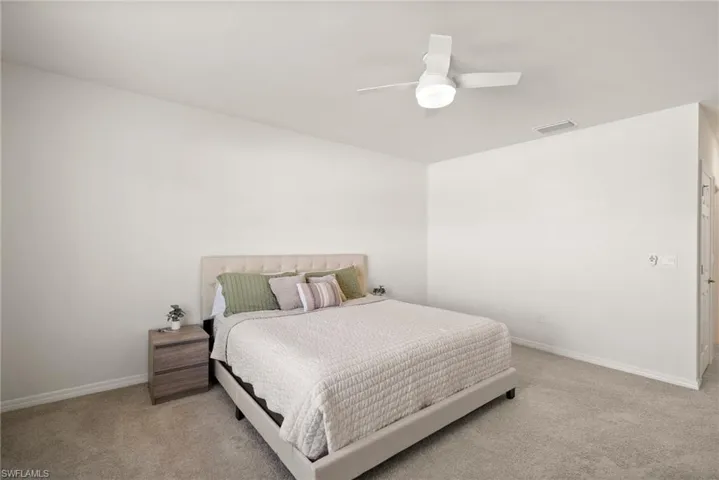 Carpeted bedroom featuring ceiling fan