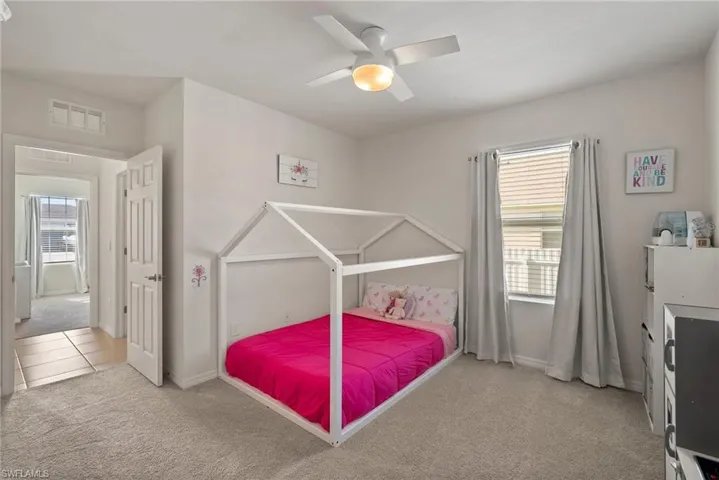 Bedroom featuring ceiling fan, carpet floors, and multiple windows