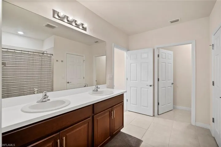 Bathroom with tile patterned flooring, vanity, and walk in shower