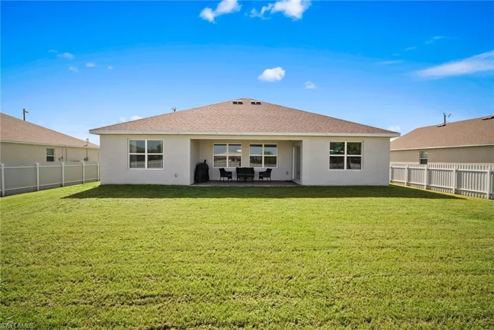 Rear view of property featuring a patio area and a yard
