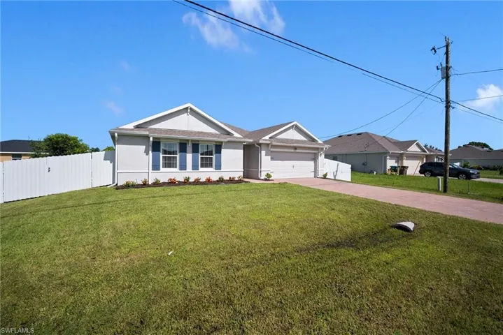 Ranch-style home with a garage and a front lawn