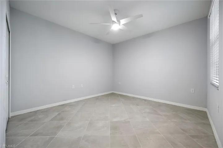 Second bedroom with tile flooring & a ceiling fan