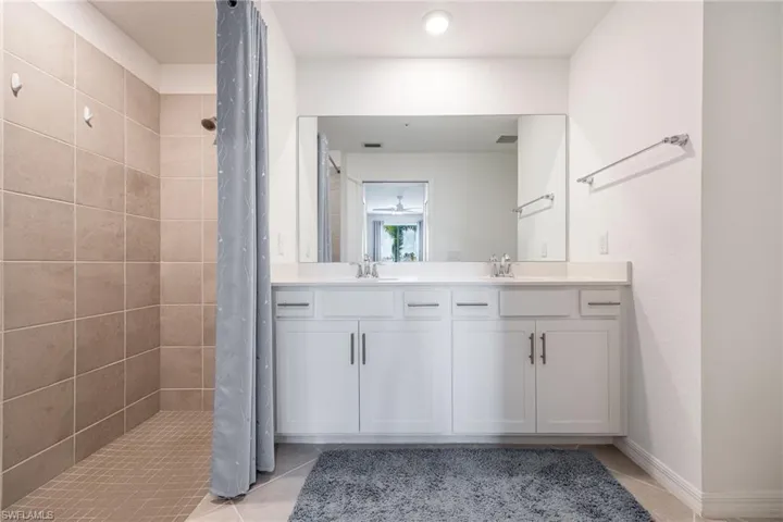 Primary bathroom with dual sinks & a tiled shower