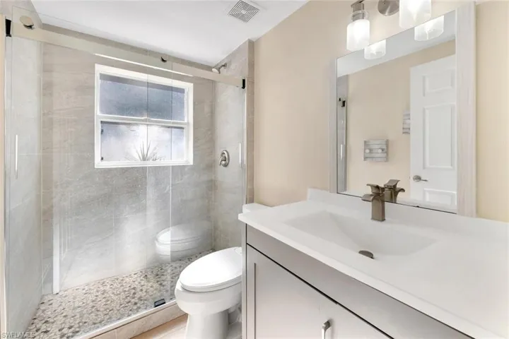 Guest Bathroom featuring vanity, toilet, and walk in shower