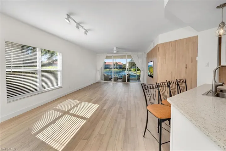 Dining room featuring ceiling fan, light wood-type flooring, sink, and a wealth of natural light
