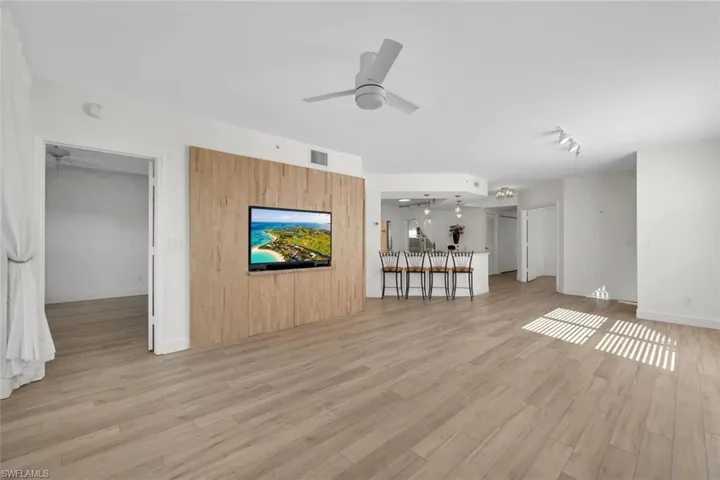 Unfurnished living room featuring light wood-type flooring and ceiling fan