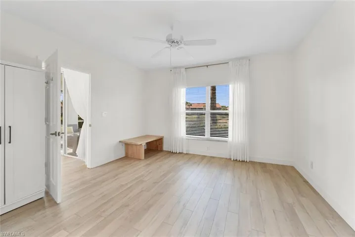 Primary bedroom featuring light wood-type flooring and ceiling fan