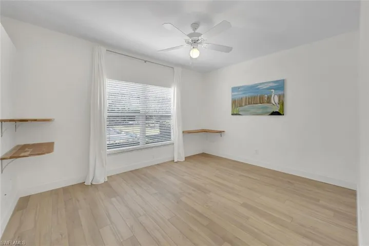 Guest bedroom with light hardwood / wood-style flooring and ceiling fan