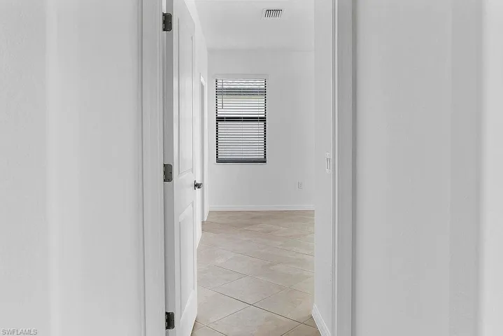 Recessed lighting, white paneled doors, and ceramic tile flooring