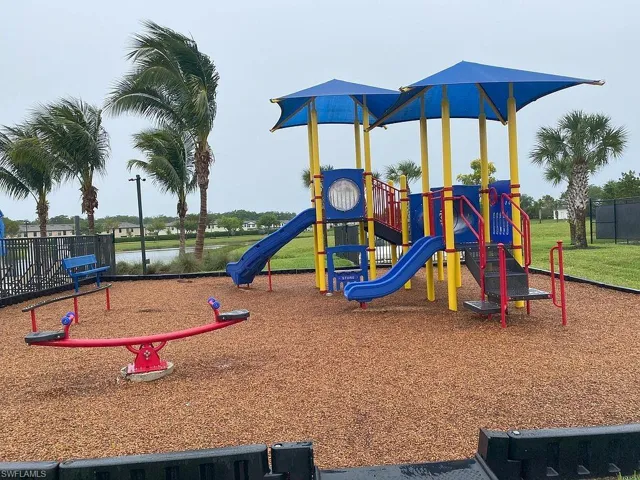 Playground featuring multiple slides, stairs, and overhead sunshades