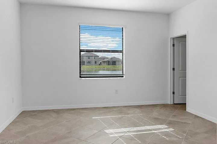 Tile flooring, neutral wall finish, window with horizontal blinds, interior door