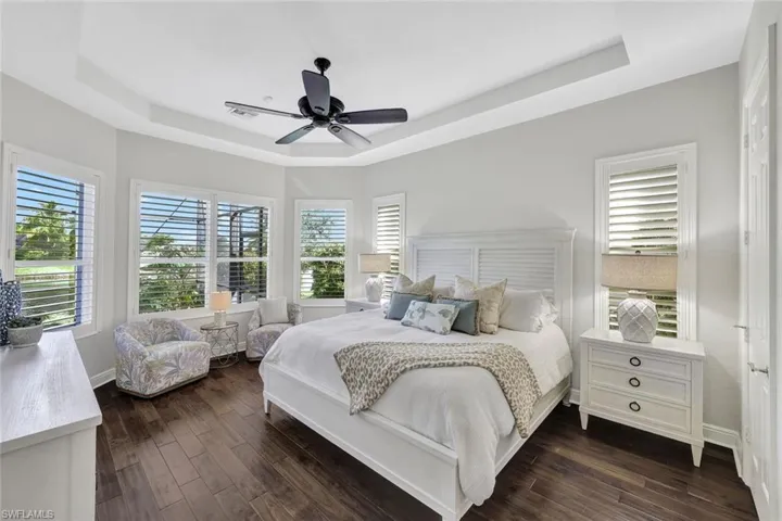Bedroom featuring a tray ceiling, ceiling fan, and dark hardwood / wood-style floors