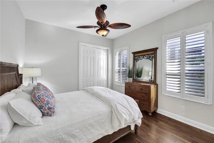 Bedroom featuring ceiling fan, dark hardwood / wood-style floors, and a closet