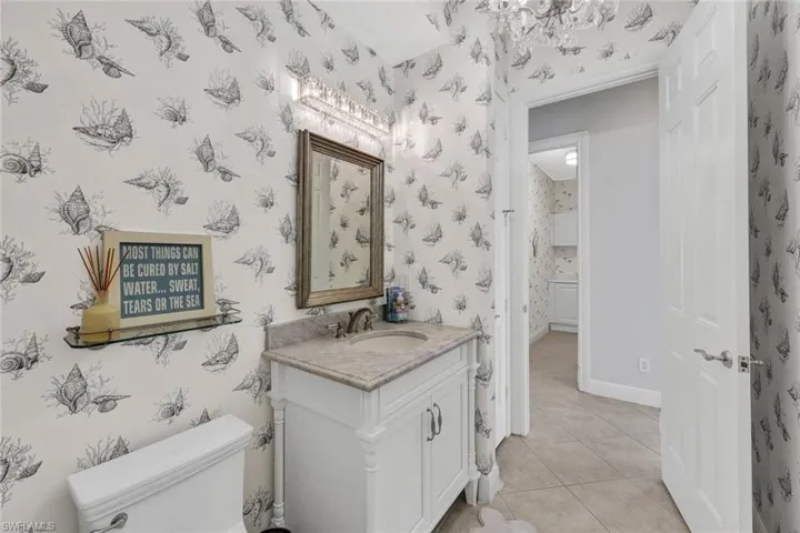 Bathroom with toilet, tile patterned flooring, and vanity