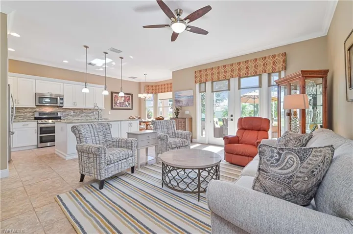 Tiled living room with french doors, ceiling fan, ornamental molding, and sink