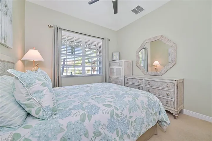 Carpeted bedroom featuring ceiling fan