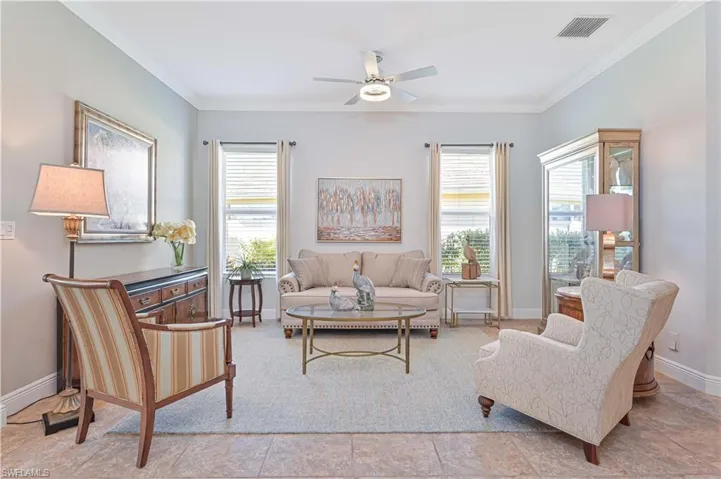 Living room featuring crown molding, plenty of natural light, and ceiling fan
